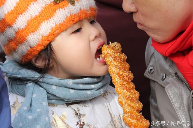 美食谁不爱？青岛庙会饕餮百态看得流口水，美女吃糖球不颇形象