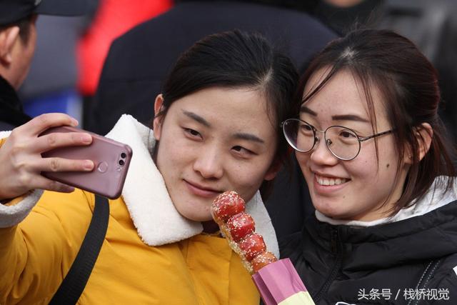 美食谁不爱？青岛庙会饕餮百态看得流口水，美女吃糖球不颇形象