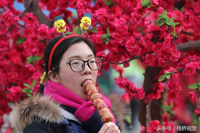 美食谁不爱？青岛庙会饕餮百态看得流口水，美女吃糖球不颇形象