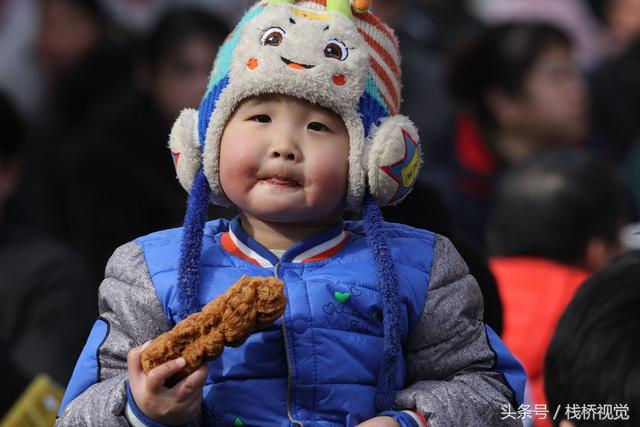 美食谁不爱？青岛庙会饕餮百态看得流口水，美女吃糖球不颇形象