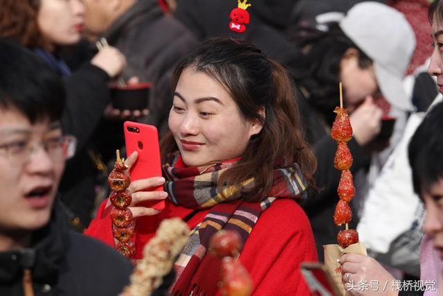 美食谁不爱？青岛庙会饕餮百态看得流口水，美女吃糖球不颇形象