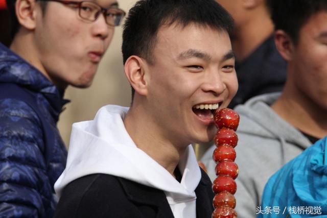 美食谁不爱？青岛庙会饕餮百态看得流口水，美女吃糖球不颇形象