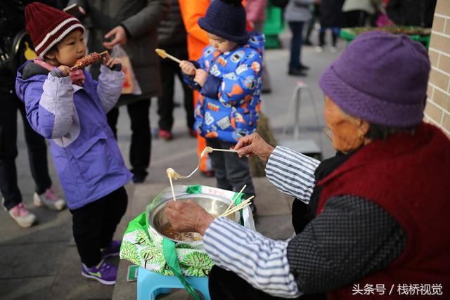 美食谁不爱？青岛庙会饕餮百态看得流口水，美女吃糖球不颇形象