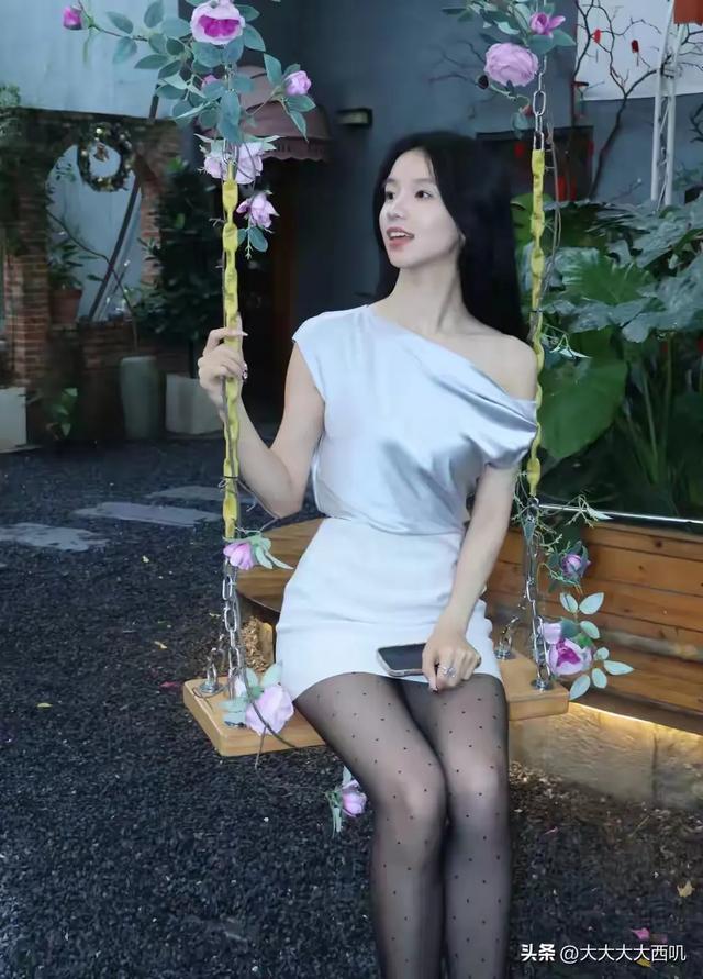 27岁白色连衣裙黑丝袜蓝色高跟鞋美女，花园坐着拍摄写真照！