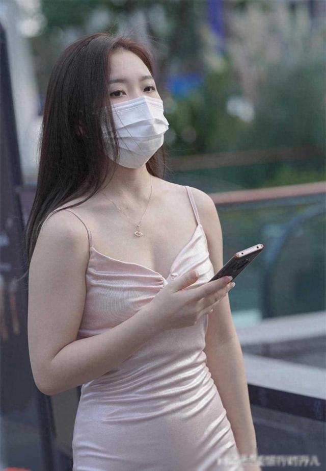 长发美女一袭淡粉色真丝吊带鱼尾长裙，脚踩粉色高跟鞋，韵味十足